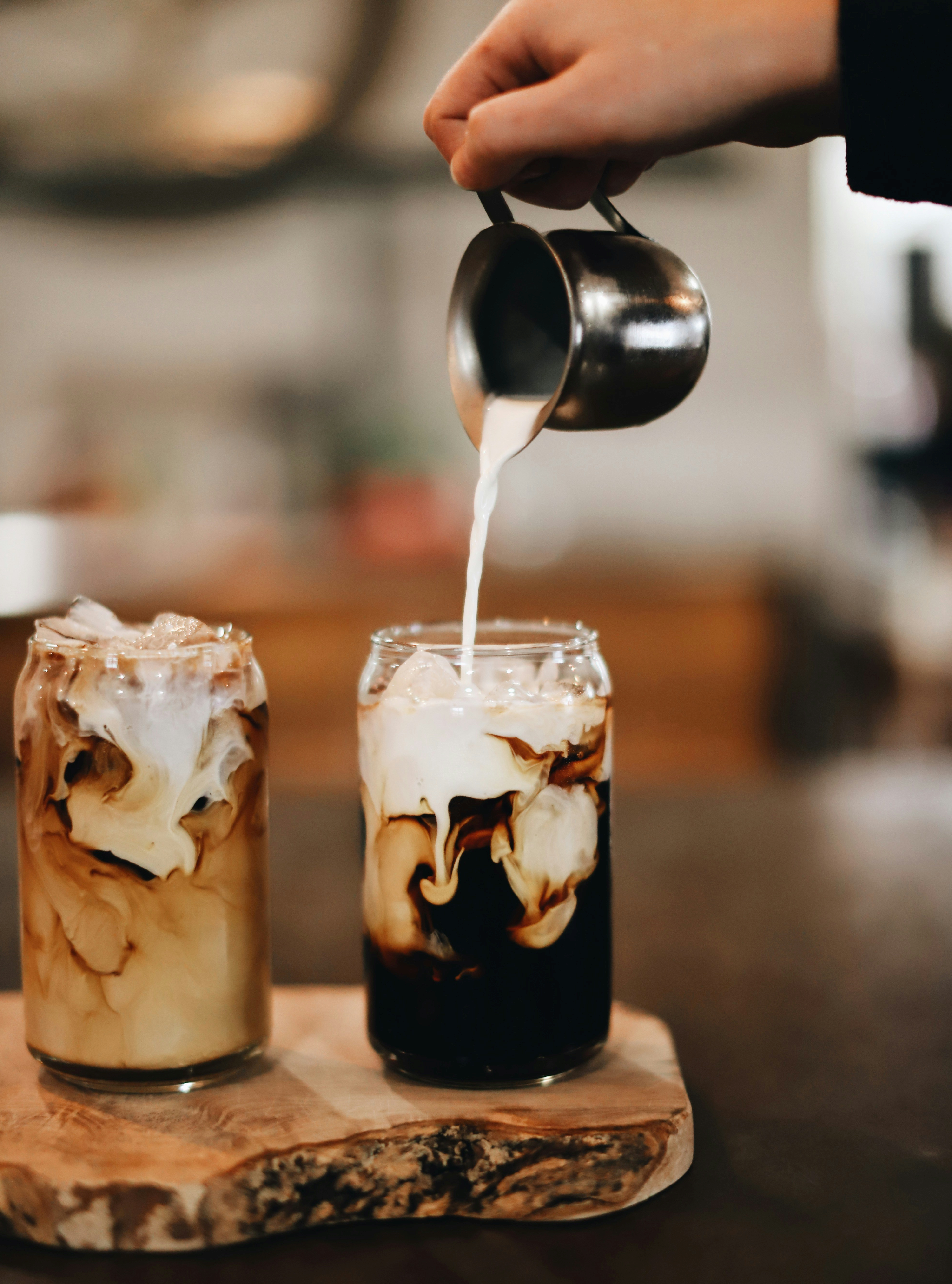 Two coffee glasses with coffee being poured in one